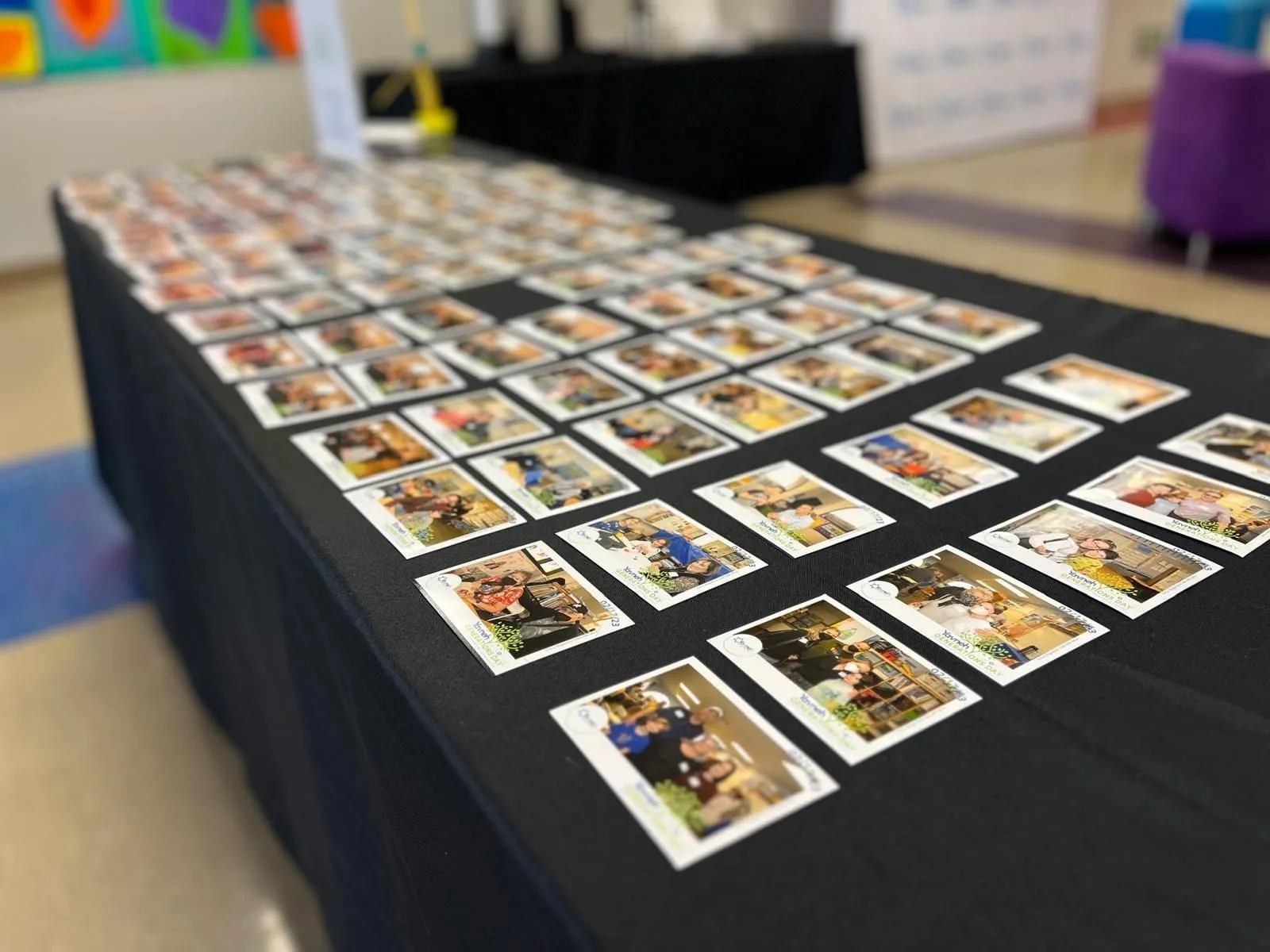 Hundreds of custom-framed magnet keepsakes laid out on a table at a Bay Area event, ready for guests to pick up.