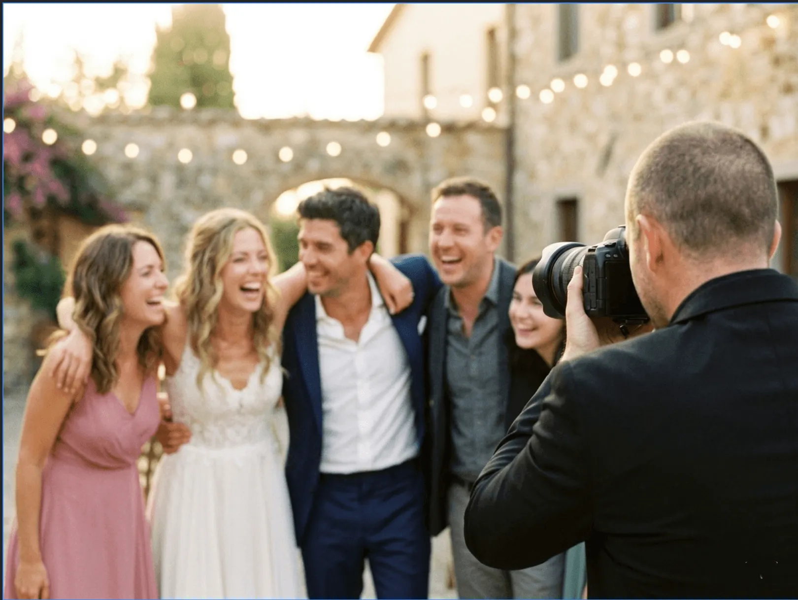 A Magneteam roaming photographer photographing the wedding party at an outdoor reception.
